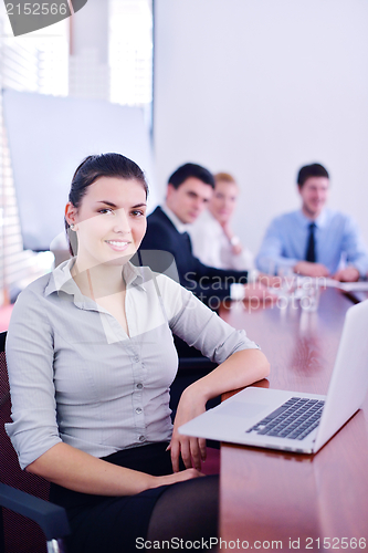Image of business woman with her staff in background at office