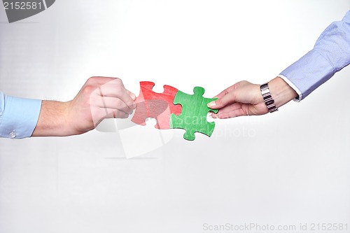 Image of Group of business people assembling jigsaw puzzle