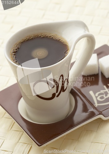 Image of choco latte. A white cup of coffee on a support.