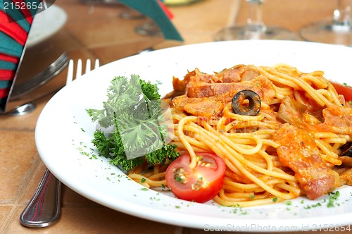 Image of Spaghetti with a tomato sauce on a table in cafe 