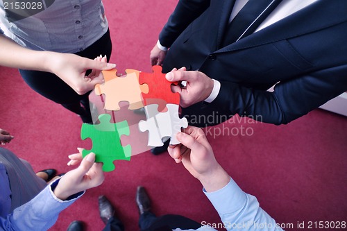 Image of Group of business people assembling jigsaw puzzle