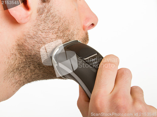 Image of Young man shaving his beard off