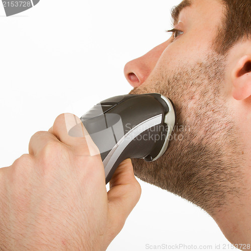 Image of Young man shaving his beard off