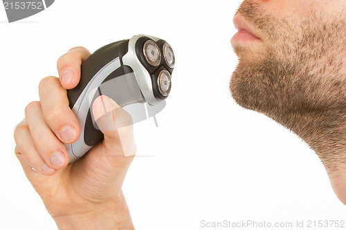 Image of Young man shaving his beard off