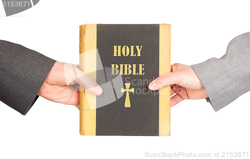 Image of Man and woman in business suits are holding a holy bible