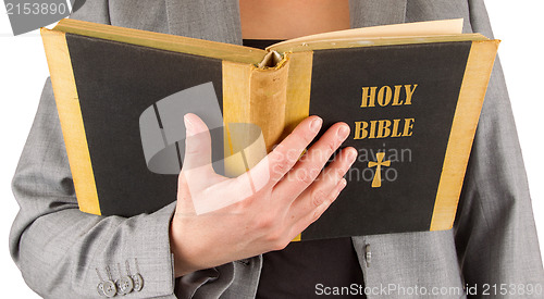 Image of Woman in business suit is reading a holy bible