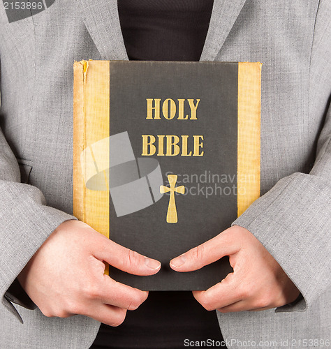 Image of Woman in business suit is holding a holy bible