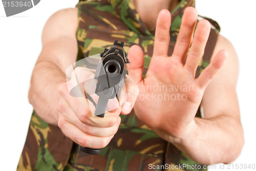 Image of Soldier in camouflage vest is holding a gun