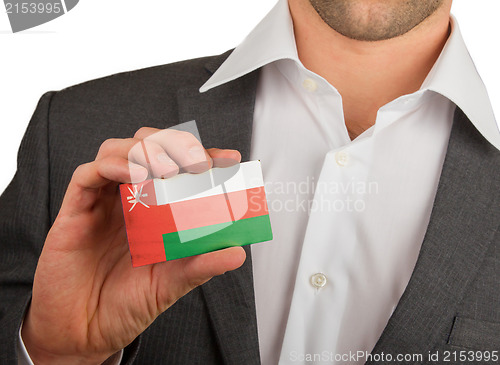 Image of Businessman is holding a business card, Oman