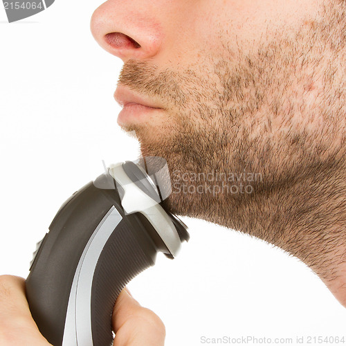 Image of Young man shaving his beard off