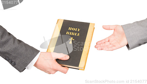 Image of Man and woman in business suits are holding a holy bible