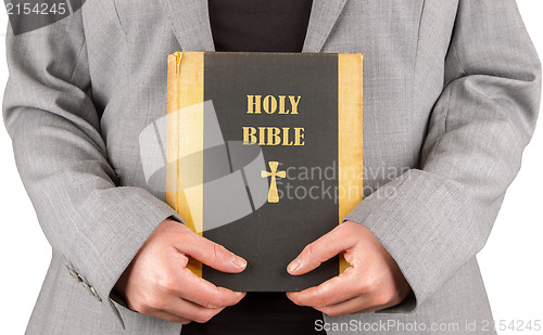 Image of Woman in business suit is holding a holy bible