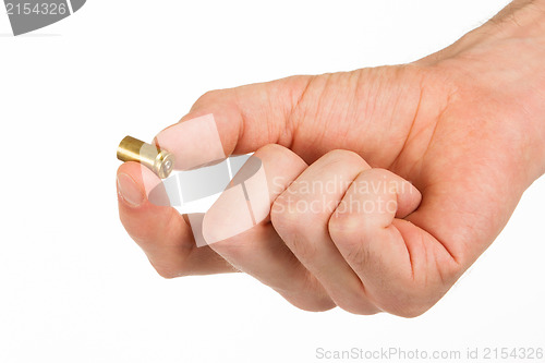 Image of Hand holding an empty bullet shell