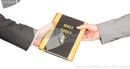 Image of Man and woman in business suits are holding a holy bible