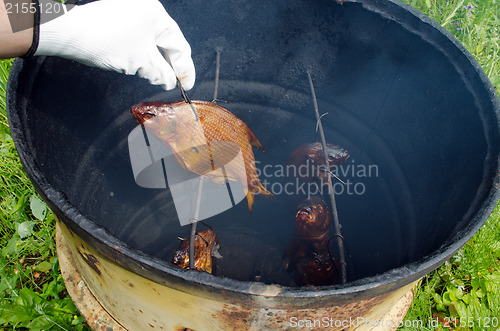 Image of hand glove smoke tench fish smokehouse barrel 