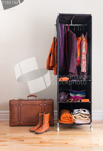 Image of Mobile wardrobe with clothing and leather suitcase