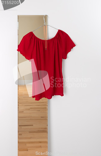 Image of Red blouse hanging on a mirror