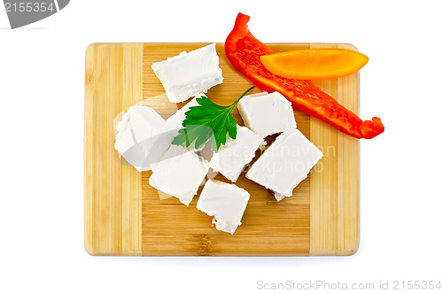 Image of Feta cheese pieces on the board with pepper