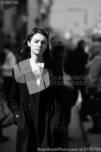 Image of Young woman among human rush in the city