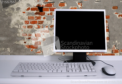 Image of PC with black desktop and old grunge brick wall background