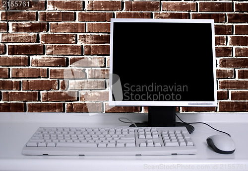 Image of PC with black desktop and brick wall background