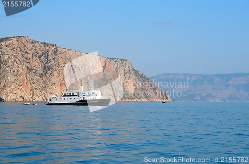 Image of Ship and several boats going into the sea.