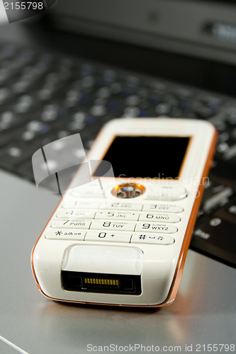 Image of Mobile phone on a laptop