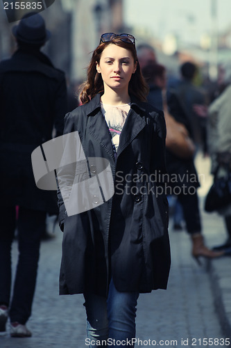 Image of Young woman among human rush in the city