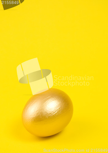 Image of Golden egg on yellow background. Lots of space for text