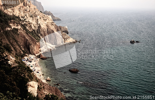 Image of Sea with rocky beach at sunset
