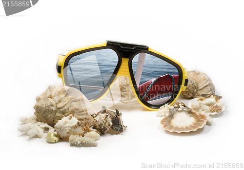 Image of Yellow diving mask with sea shells and sea reflection