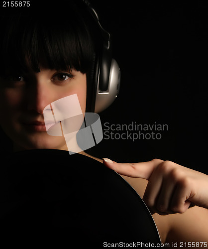 Image of Naked girl with vinyl plate and headphones