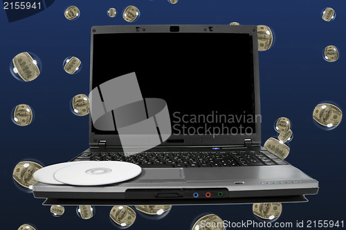 Image of White cd`s on a laptop with black desktop. Cool dollar bubbles b