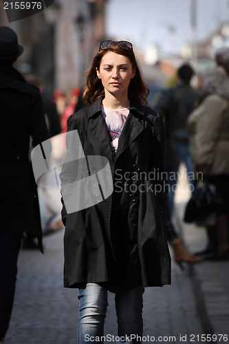 Image of Young woman among human rush in the city