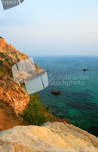 Image of Sea with rocky beach at sunset