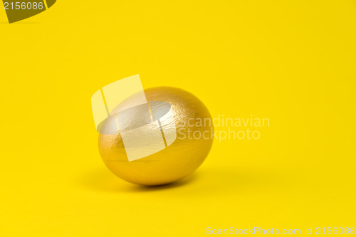 Image of Golden egg on yellow background. Lots of space for text