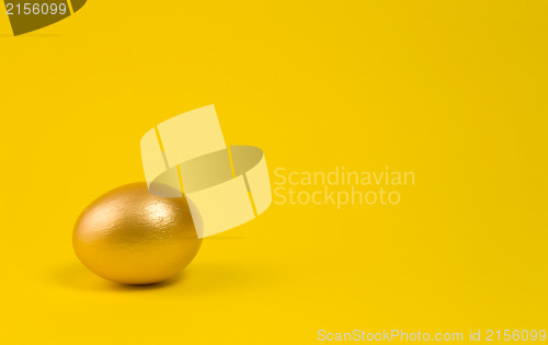 Image of Golden egg on yellow background. Lots of space for text