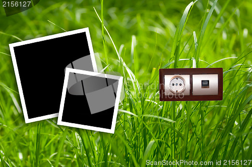 Image of Energy outlet in grass with empty frames.Environment concept.