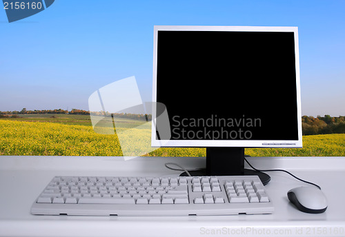 Image of PC with black desktop and green field background