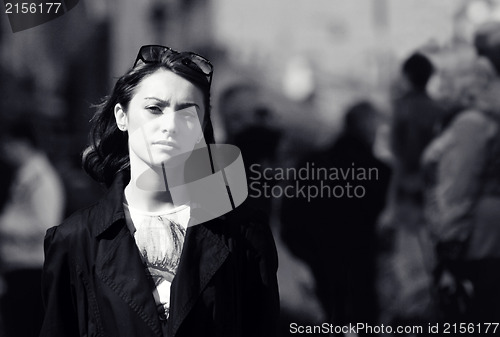 Image of Young woman among human rush in the city