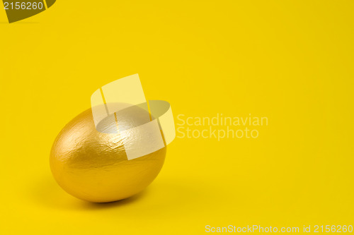 Image of Golden egg on yellow background. Lots of space for text