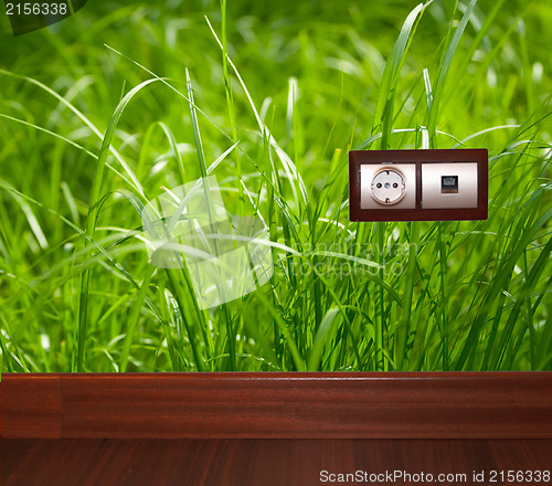 Image of Electric outlet in grass.Ecology clean electricity concept.