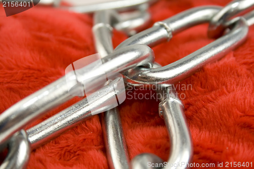 Image of Steel chain on red fabric