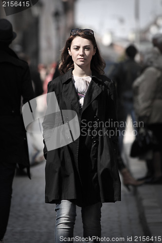 Image of Young woman among human rush in the city