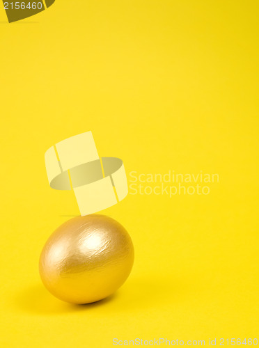 Image of Golden egg on yellow background. Lots of space for text