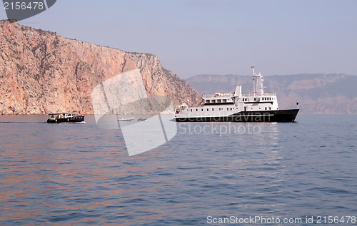 Image of Ship and several boats going into the sea.