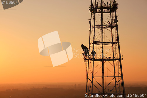 Image of Communication tower at sunset with cityscape