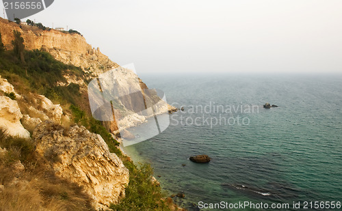 Image of Sea with rocky beach at sunset