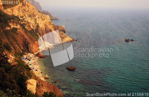 Image of Sea with rocky beach at sunset