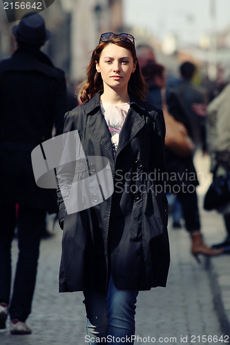 Image of Young woman among human rush in the city